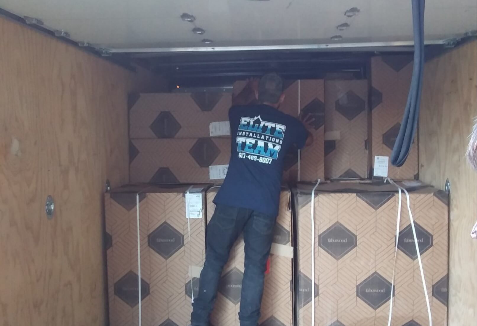 a man standing on a truck with boxes in the back